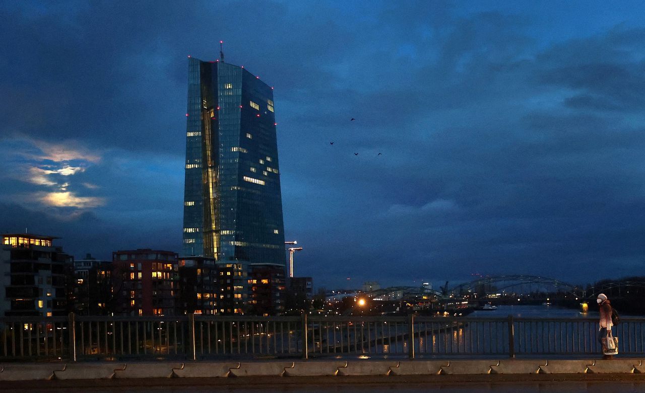 Een vrouw loopt langs het hoofdkantoor van de ECB in Frankfurt