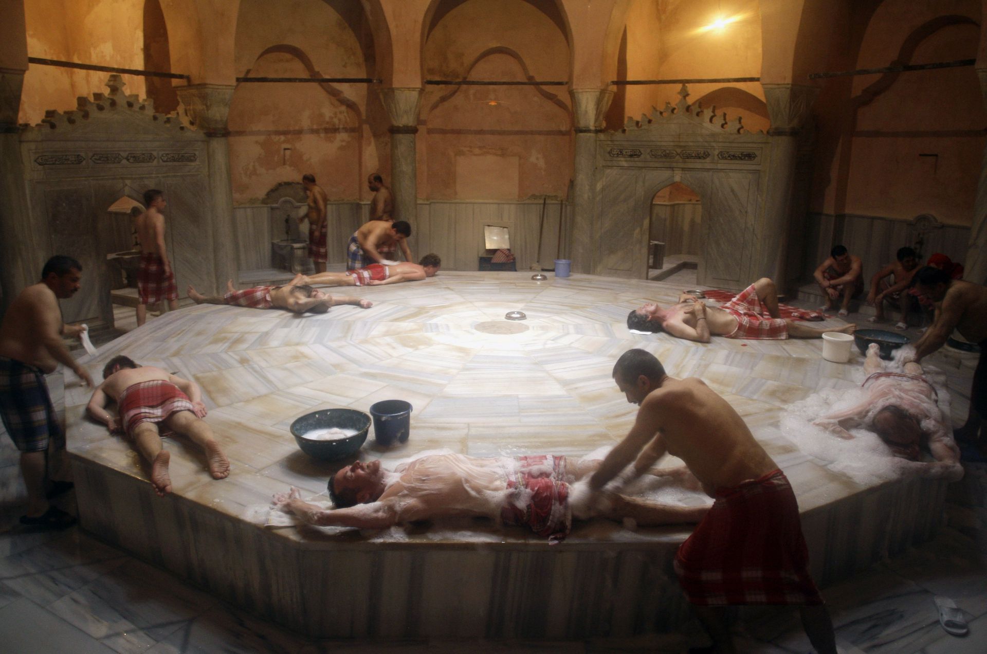 Usta / AP Turkish men and tourists enjoy a traditional bath in the historic...