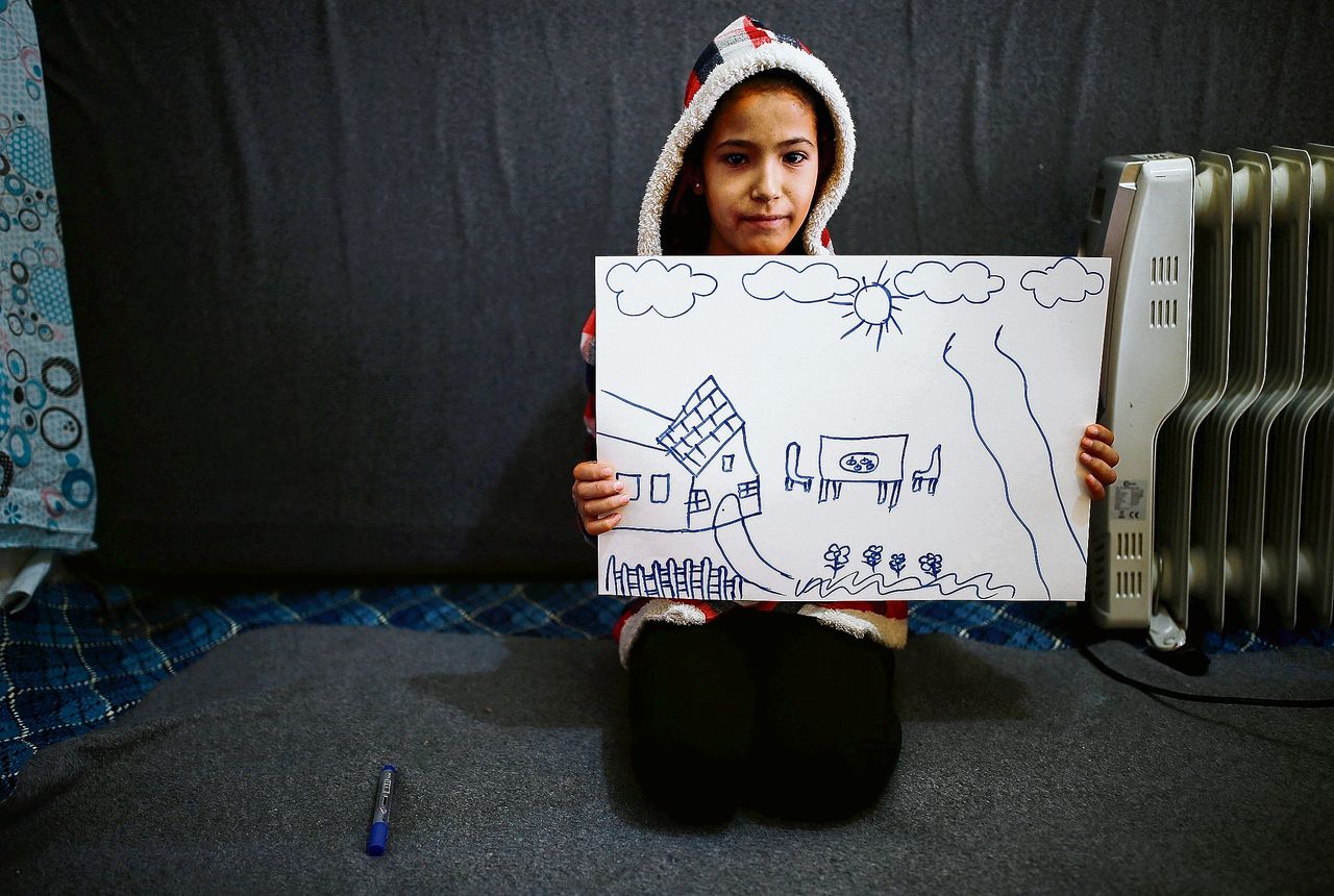 Rahaf Hasan (10 jaar), in een Turks vluchtelingenkamp, toont tekeningen van haar huis in Syrië.