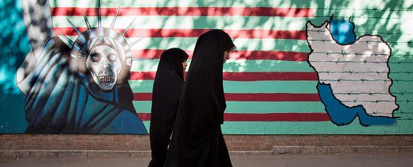 EDITORS' NOTE: Reuters and other foreign media are subject to Iranian restrictions on leaving the office to report, film or take pictures in Tehran. Iranian women walk past an anti-U.S. mural on the wall of the former U.S. embassy in Tehran October 12, 2011. U.S. authorities said on Tuesday that they had broken up a plot by two men linked to Iran's security agencies to kill the Saudi envoy, Adel al-Jubeir. One man was arrested last month while the other was believed to be in Iran. REUTERS/Morteza Nikoubazl (IRAN - Tags: POLITICS) IPTC Date: 09:23 12/10/11 Arrival Date: 11:23 12/10/11 Notes: