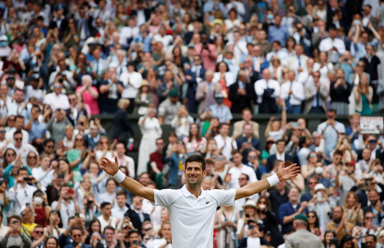 Novak Djokovic viert zijn winst op Wimbledon.