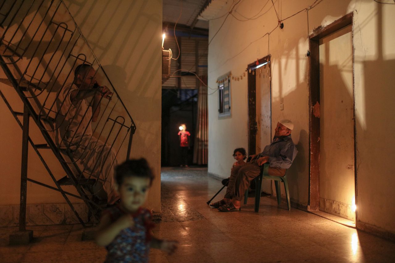 Een Palestijns gezin in Gaza bij kaarslicht. Stroom is er een luxe.