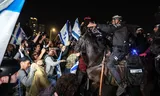 De bereden politie probeert demonstranten die een snelweg blokkeren tijdens protesten in Tel Aviv uiteen te drijven. 