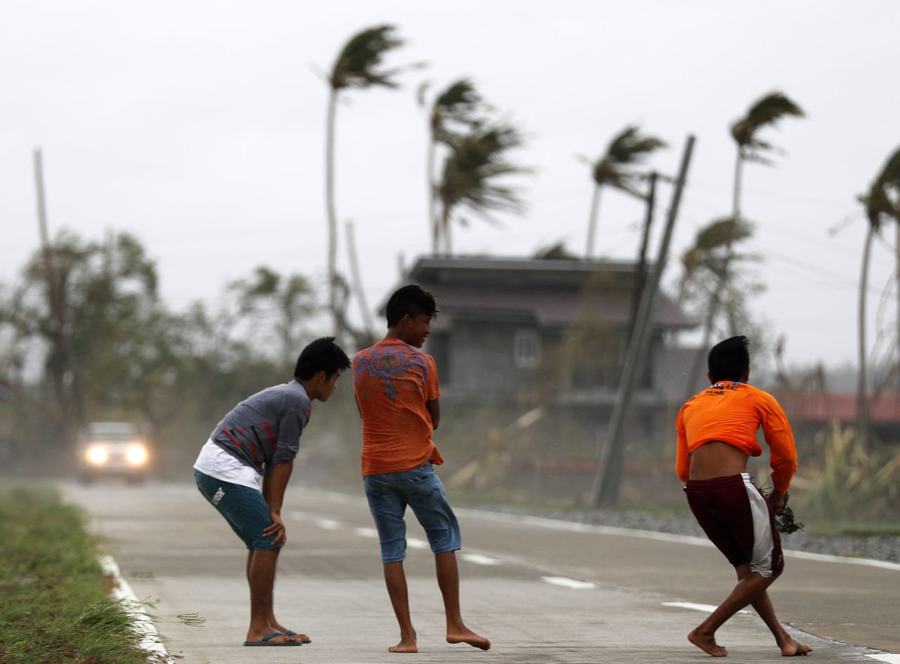 Jonge dorpelingen in Baggao, in de Filppijnse provincie Cagayan, zaterdag in de wind van tyfoon Mangkhut.