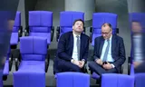 SPD leader Lars Klingbeil (left) and CDU leader Friedrich Merz consult in the Bundestag, March 13.   