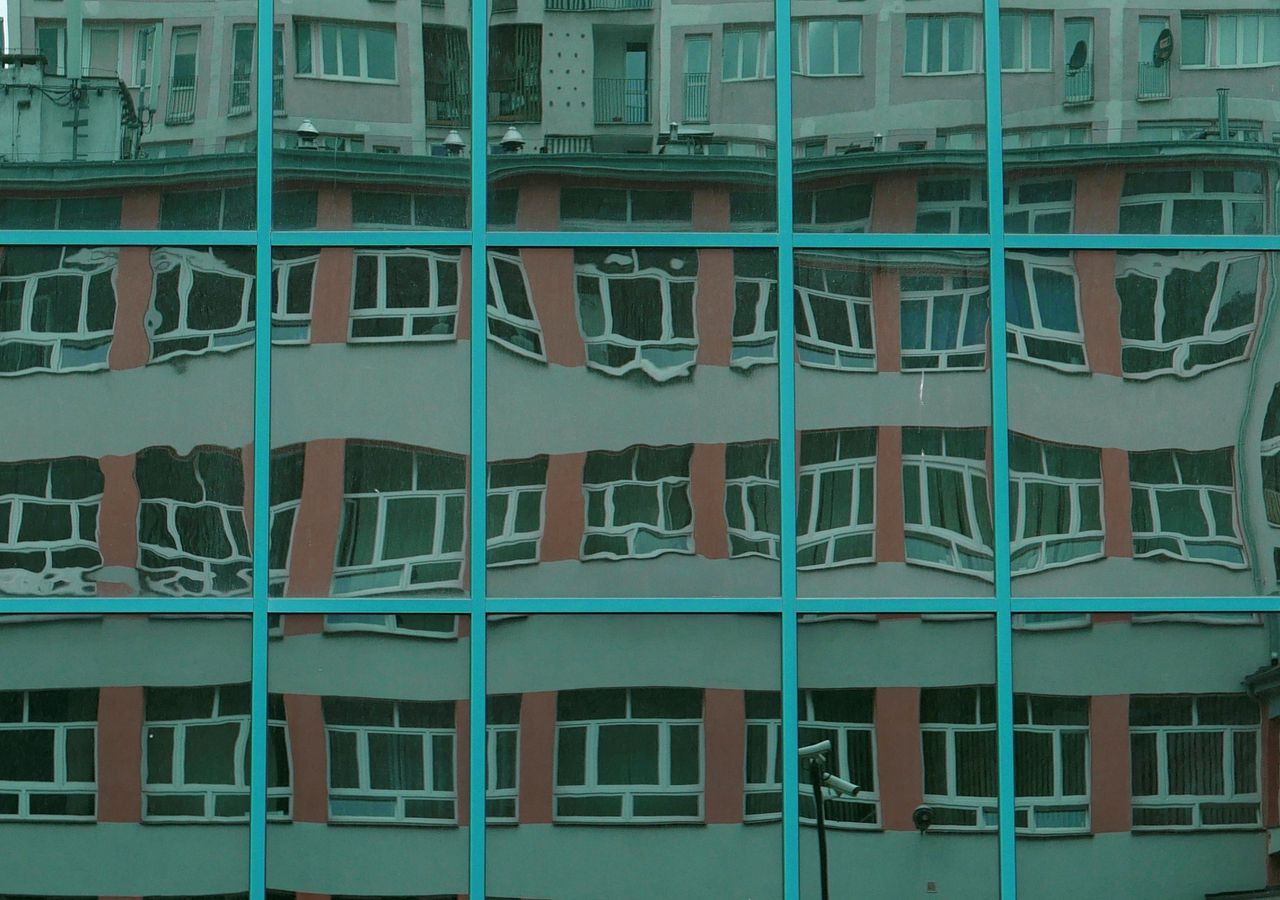Appartementen in Warschau, weerspiegeld in de ramen van een kantoorgebouw.