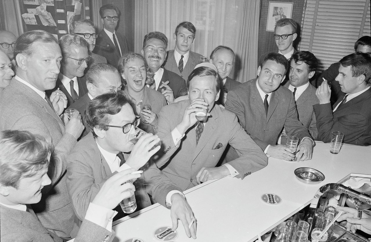1967, Prins Claus drinkt, omringd door journalisten, een pilsje tijdens een bezoek aan perscentrum Nieuwspoort.
