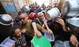 Palestinos en un punto de distribución de alimentos en Nuseirat, Franja de Gaza, el lunes. Foto: Eyad Baba/AFP