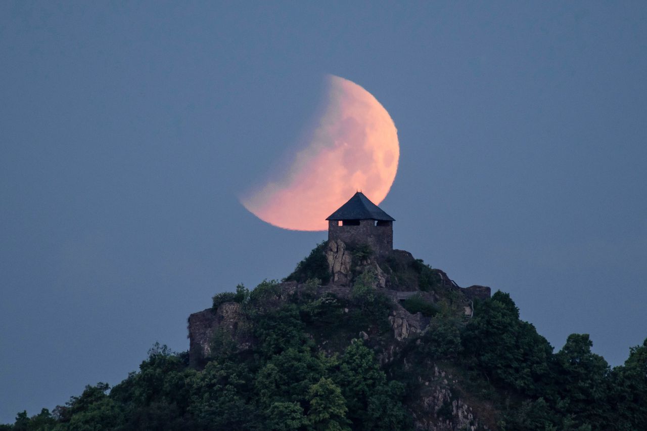 De maan hangt boven het Salgokasteel in Hongarije, 2022.
