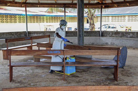 Een verpleegkundige ontsmet een behandelruimte in Liberia.