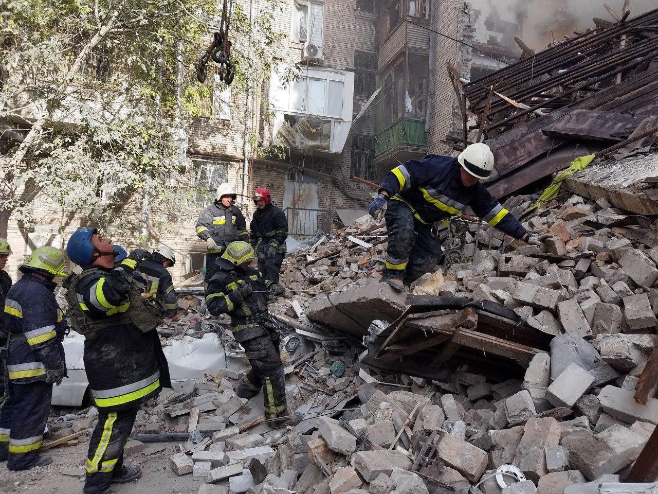 Oekraïense brandweerlieden zoeken naar overlevenden onder het puin in de stad Zaporizja.