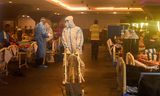 Gezondheidswerkers in een feestzaal in de Indiase hoofdstad New Delhi die nu gebruikt wordt om covidpatiënten op te vangen.