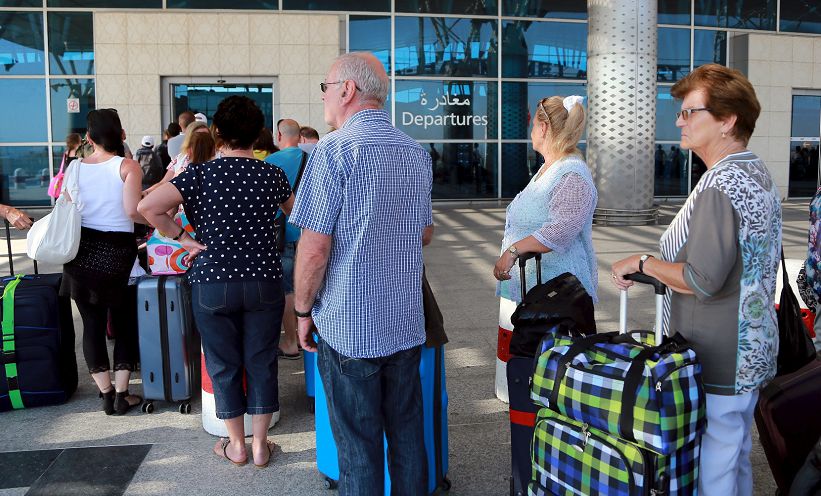 Briste toeristen staan op 11 juli 2015 in de rij bij de internationale luchthaven Enfidha in Tunesië, nadat de Britse regering toeristen had opgeroepen om Tunesië te verlaten.
