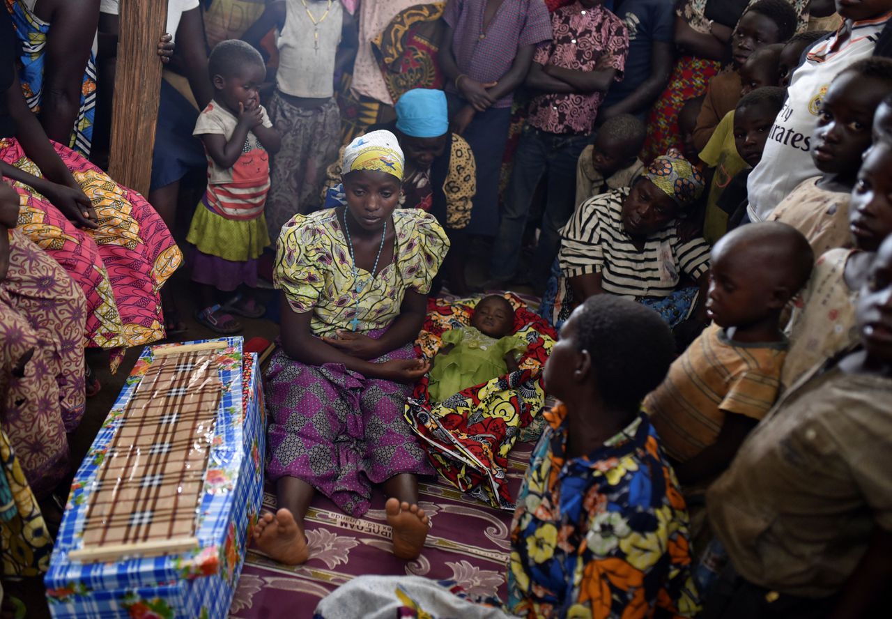 Congolezen op de begrafenis van een kind dat naar verwachting is gestorven aan de gevolgen van de mazelen, in de stad Bunia in Oost-Congo.