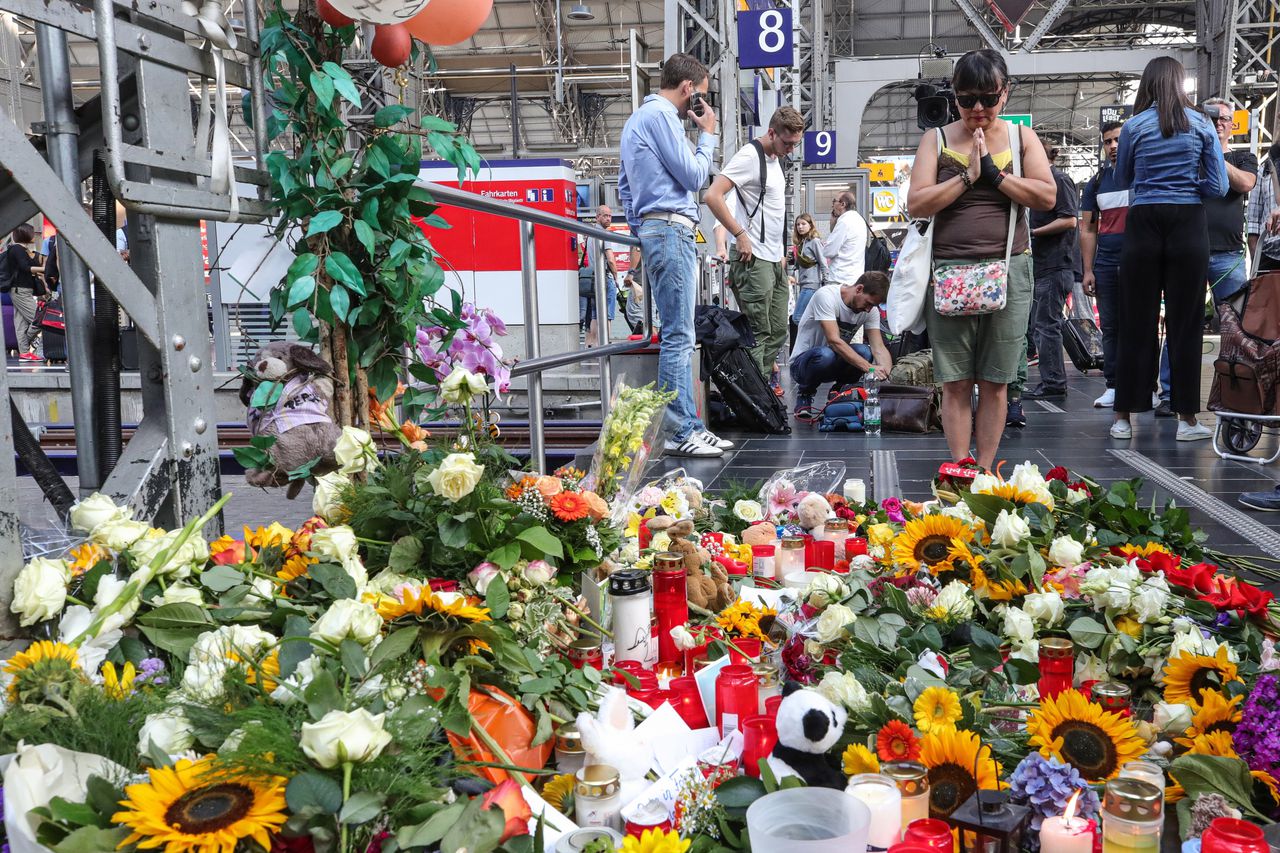 Mensen leggen bloemen op het treinstation van Frankfurt.