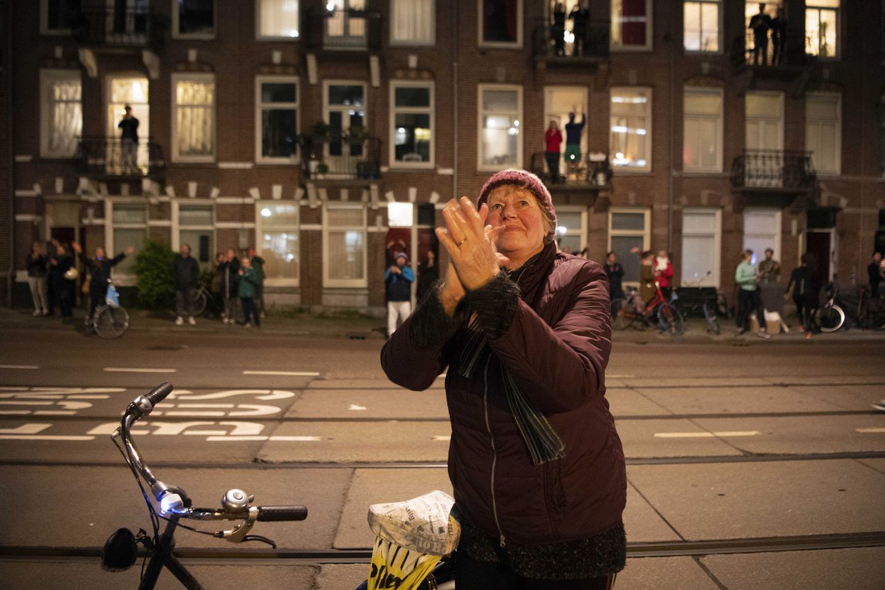 Mensen in Amsterdam doen dinsdagavond spontaan mee aan de actie #applausvoordezorg en applaudisseren voor de zorgmedewerkers.