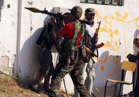 A Libyan rebel fighter prepares to fire a rocket propelled grenade launcher (RPG) towards a sniper position as they make a final push to flush out pro-Gaddafi forces from the Bab al Aziziya compound in Tripoli August 24, 2011. REUTERS/Zohra Bensemra (LIBYA - Tags: POLITICS CIVIL UNREST CONFLICT)