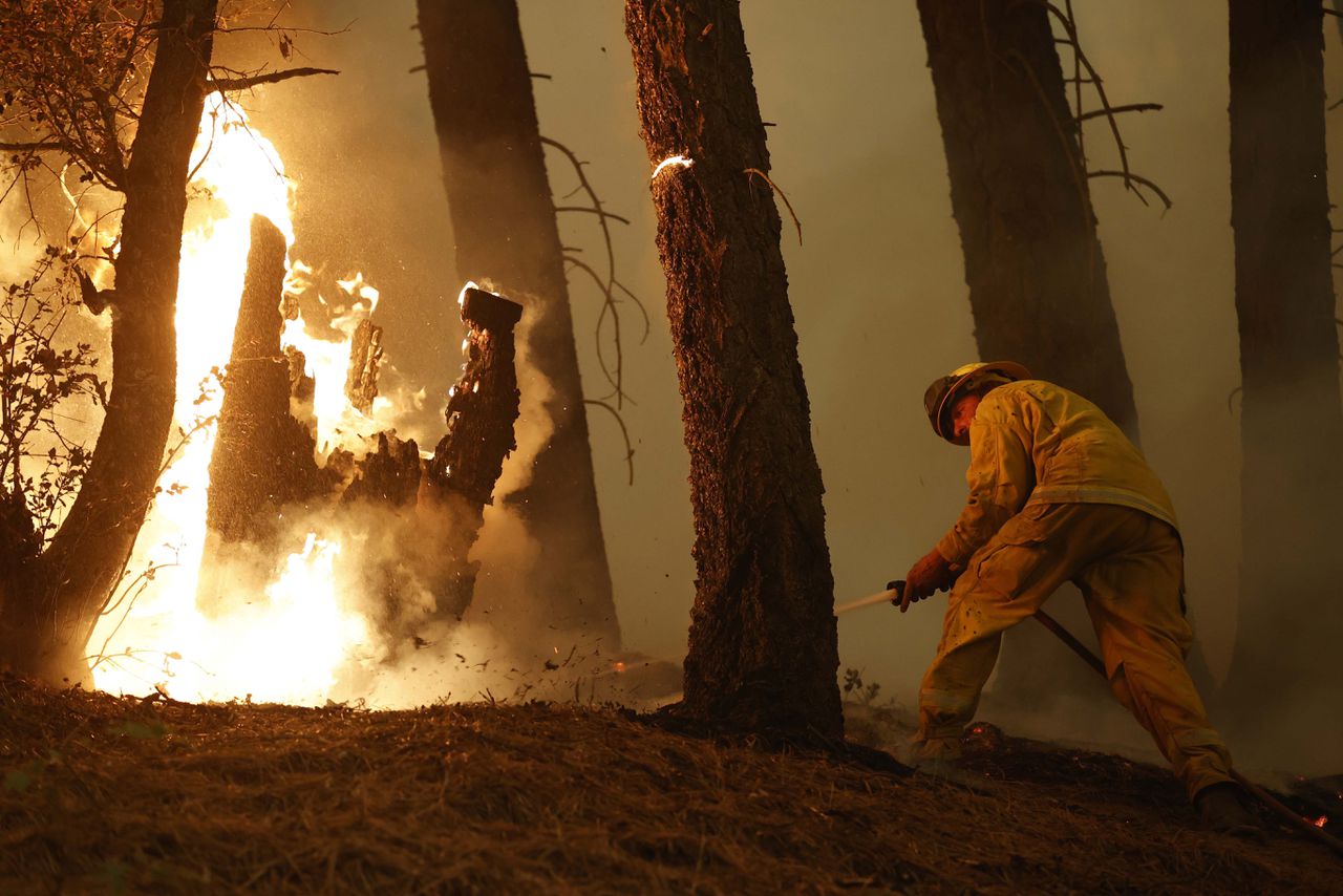 De brandweer blust de bosbrand Dixie dichtbij het plaatsje Taylorsville in Californië.