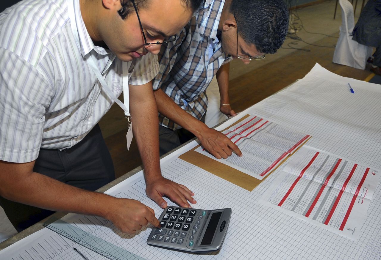Tunesische vrijwilligers tellen stemmen in Ariana, vandaag. Gisteren werd er gestemd, morgen worden officiële uitslagen verwacht. Het lijkt er sterk op dat de eens verbannen Ennahda-partij gewonnen heeft.