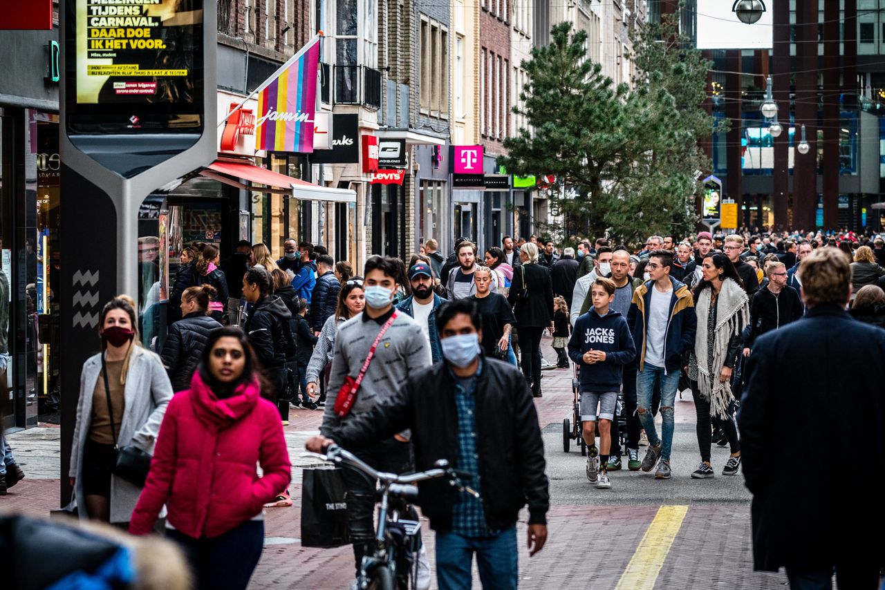 Winkelend publiek met mondkapjes tijdens een drukke koopzondag in het centrum van Eindhoven.