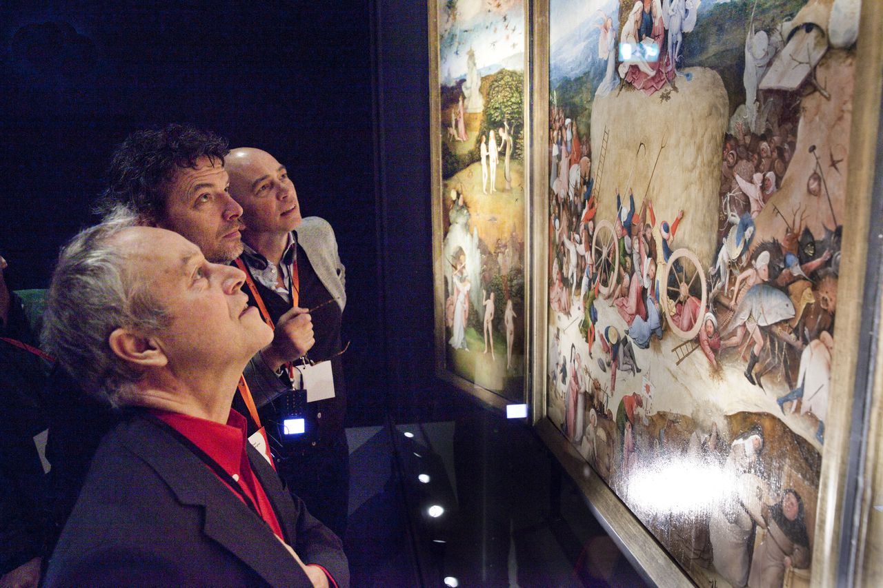 Bezoekers van een persbijeenkomst in het Noordbrabants Museum in Den Bosch kijken naar het schilderij De Hooiwagen van Jeroen Bosch.