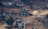 An Israeli military vehicle drives near a damaged building with a large Israeli flag in Lebanon, after Israel and Lebanon signed a framework agreement following U.S.-mediated talks, as seen from northern Israel, June 27, 2026. REUTERS/Amir Cohen     TPX IMAGES OF THE DAY     