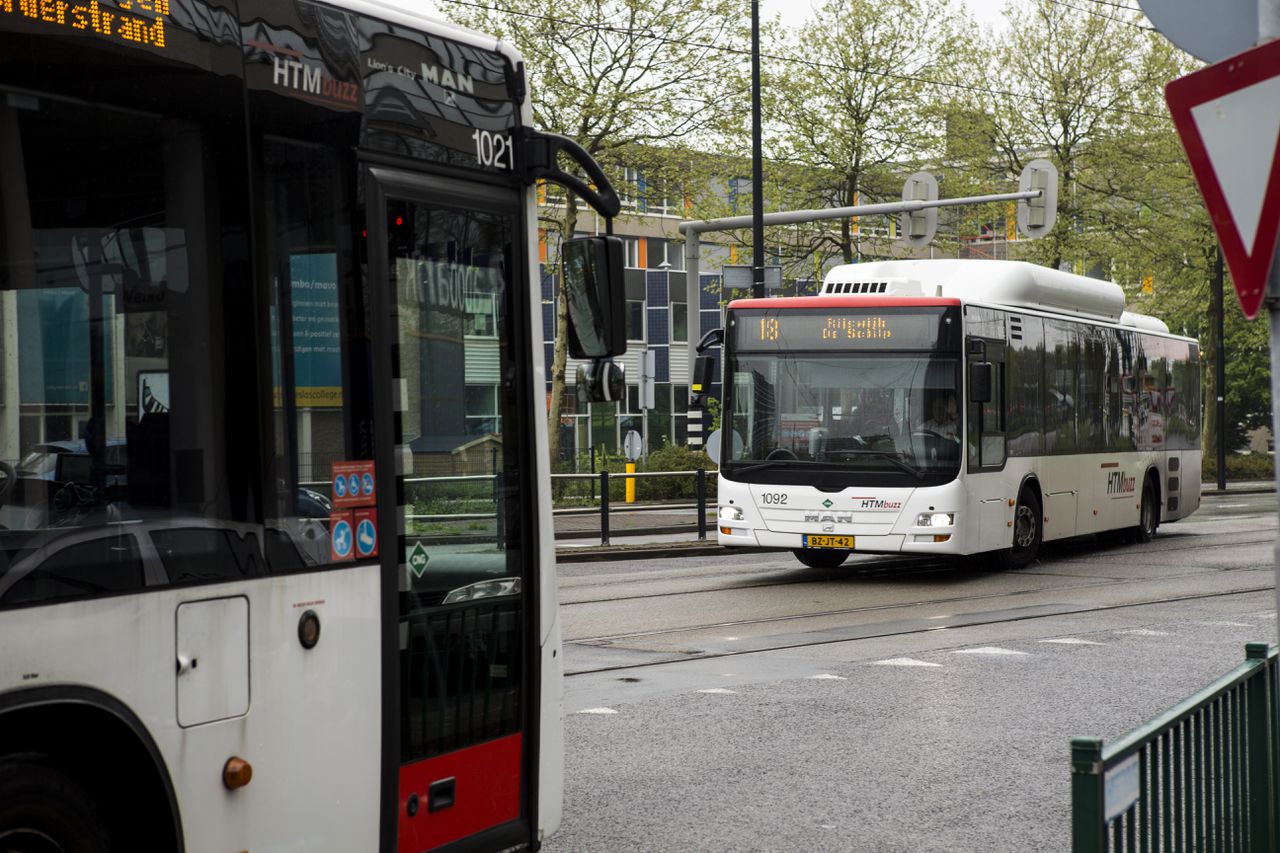 Een bus van vervoersmaatschappij HTM rijdt langs een bushalte bij station Rijswijk.