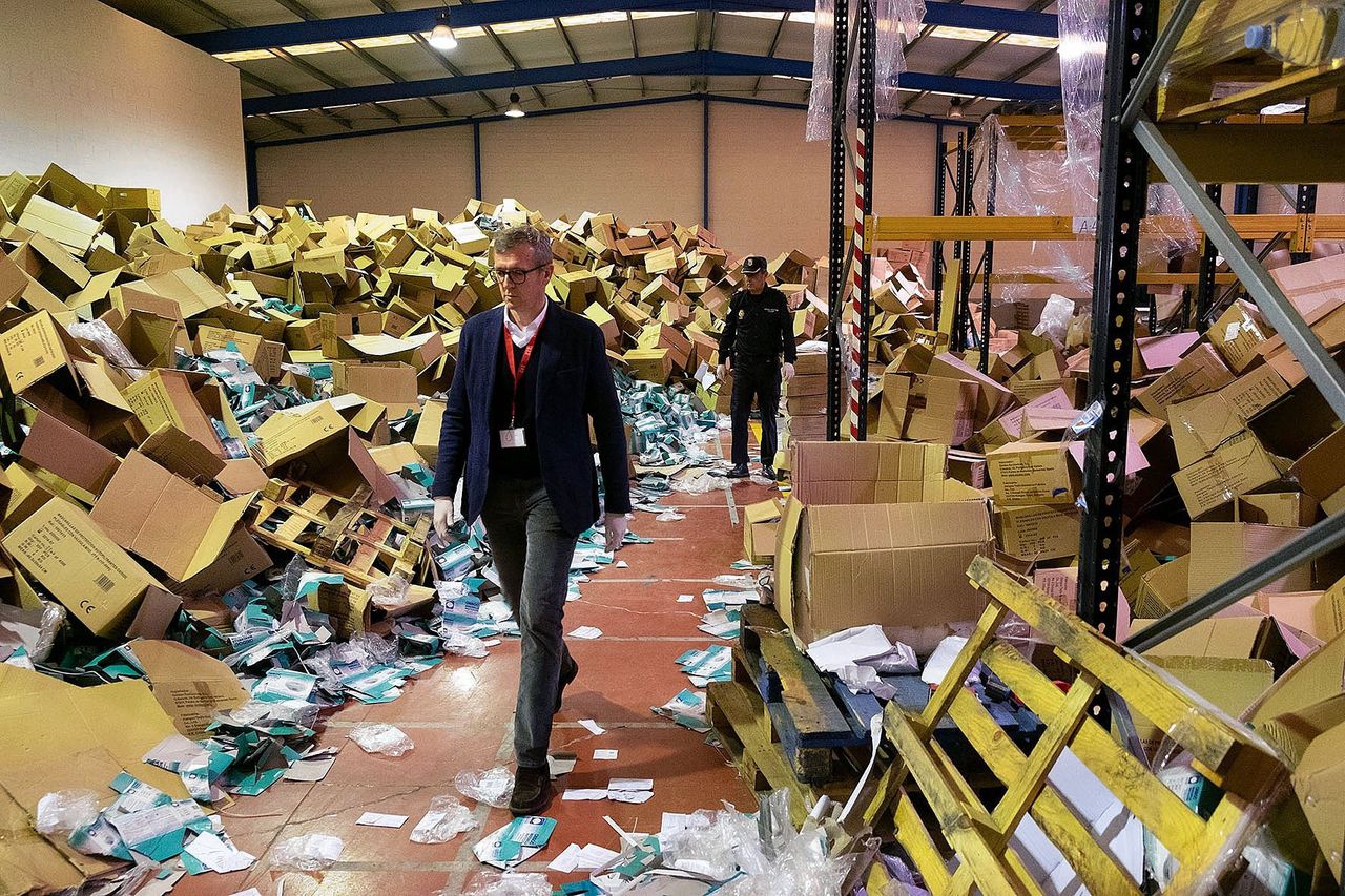 Een Spaanse overheidsfunctionaris bezoekt de opslagruimte van een bedrijf waar medische reinigingsapparatuur ter waarde van 5 miljoen euro was gestolen in Santiago de Compostela op 6 april. Foto Xoan CRESPO / AFP