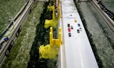 A scale model of the Oosterscheldekering, in a basin at the Deltares Knowledge Institute. Complete with toy cars. 