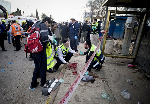 Israel Rescue workers and paramedics clean a pool of blood at a bus stop in Jerusalem, Wednesday, March 23, 2011. A bomb exploded near a crowded bus, wounding at least eight people in what appeared to be the first militant attack in the city in several years. (AP Photo/Ariel Schalit)