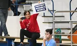 Een toeschouwer houdt een bord omhoog tijdens een wedstrijd van het volleybalteam van San Jose State, dat geboycot wordt omdat daar een transvrouw mee zou spelen