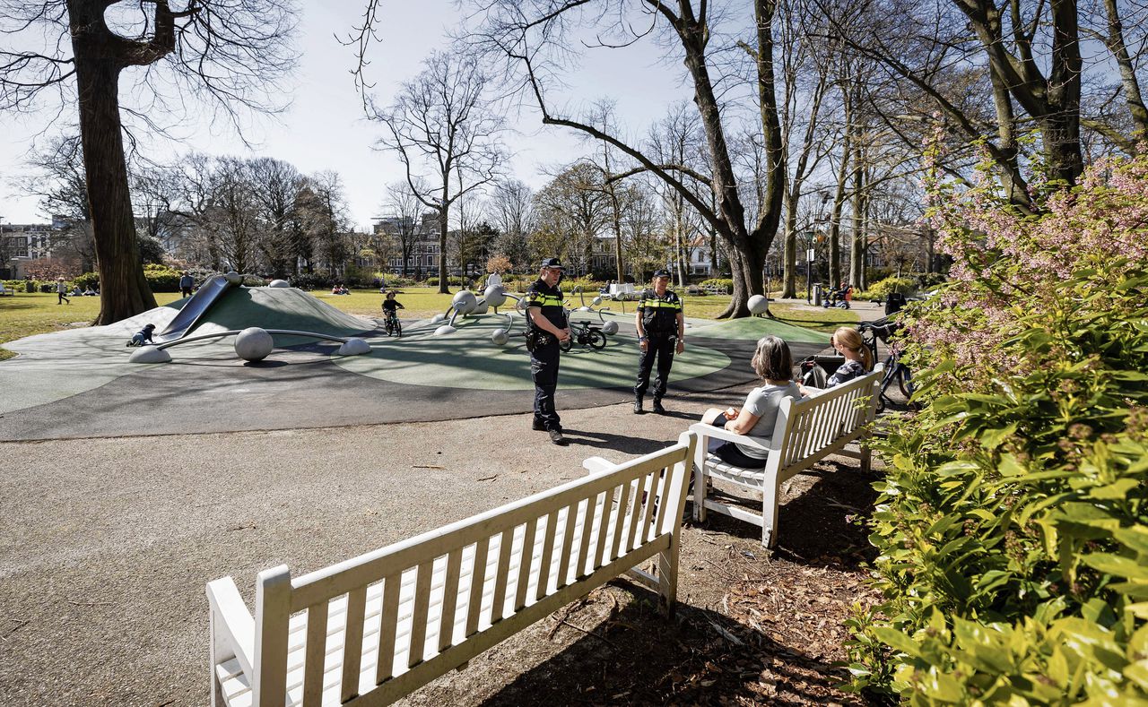 Wijkagenten in een park in Den Haag controleren of mensen zich aan de coronamaatregelen houden.
