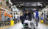 Een medewerker van Volkswagen voert een controle uit bij een auto die zojuist bij de Duitse fabrikant is voltooid. 