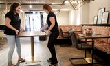 De horeca in Nederland  bereidt zich voor op de heropening op Tweede Pinksterdag. Medewerkers van het Haagse café-restaurant Luden plaatsen een tafel op 1,5 meter afstand. Sem van der Wal/ANP 