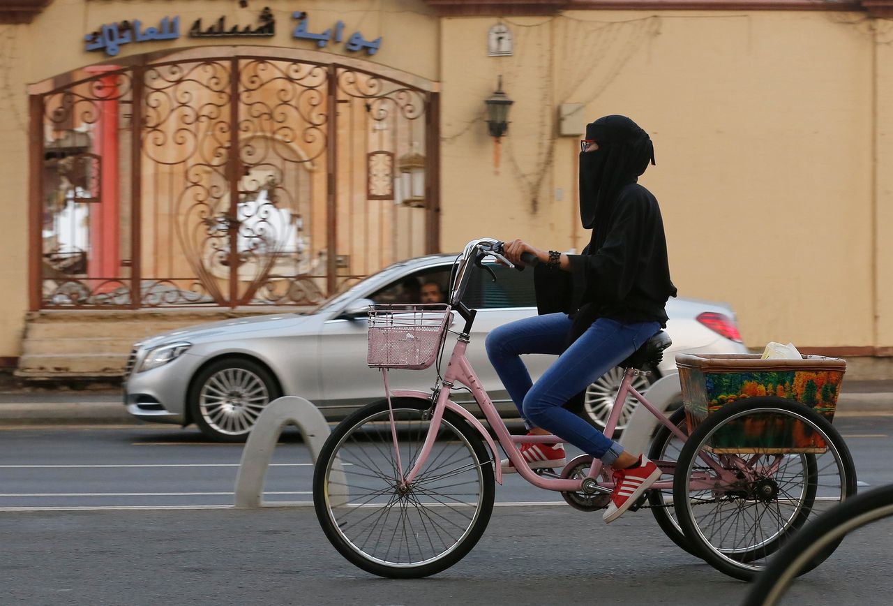 Een Saoedische vrouw te fiets in de stad Jeddah.