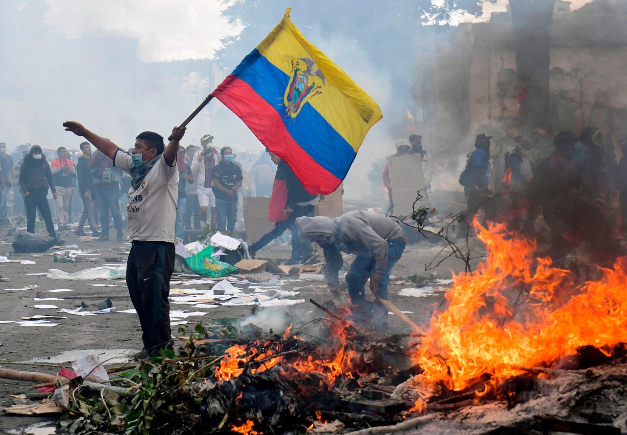 Een Ecuadoraanse demonstrant zwaait met de nationale vlag tijdens een protest tegen de verhoging van brandstofprijzen.