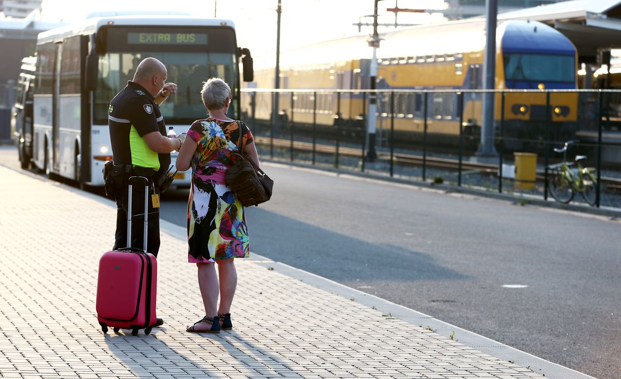 Archiefbeeld. Een NS-medewerker geeft informatie aan een reiziger op station Zwolle.