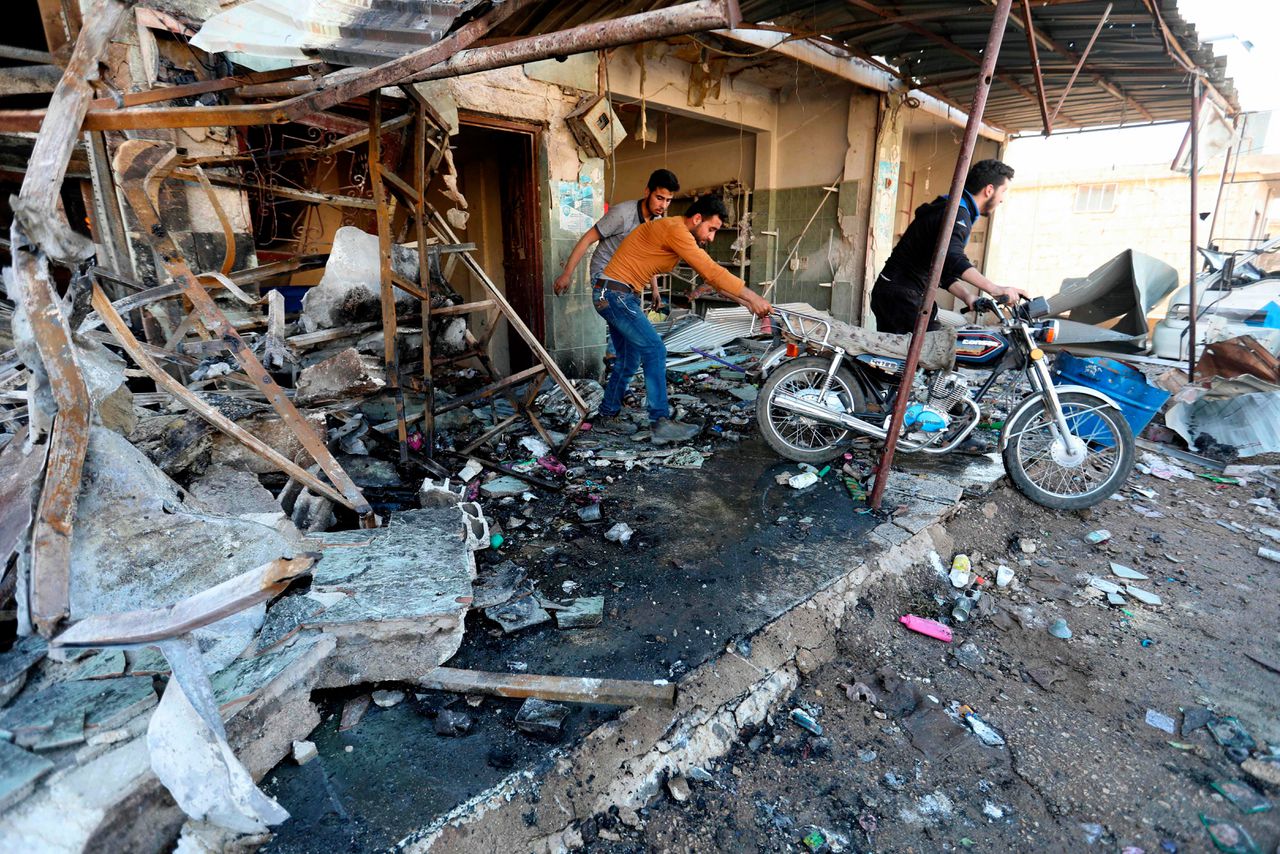 Syriërs bij een getroffen gebouw in het dorp Kafr Halab, in het westen van de provincie Aleppo.