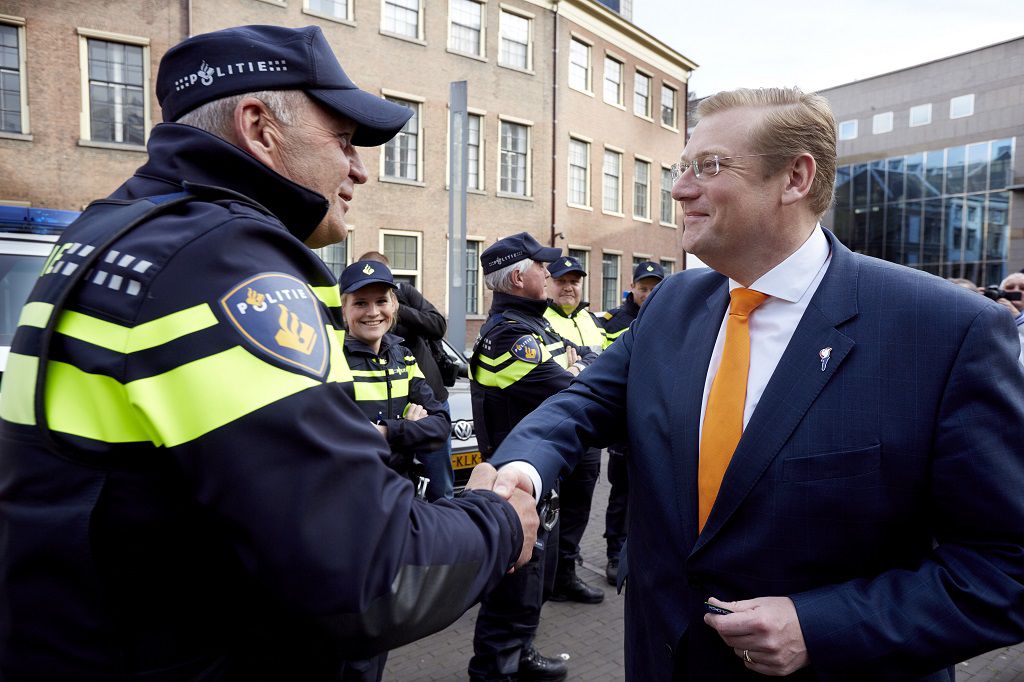 Van der Steur schudt dinsdag de hand van een politieagent tijdens een protestactie op het Buitenhof in Den Haag.