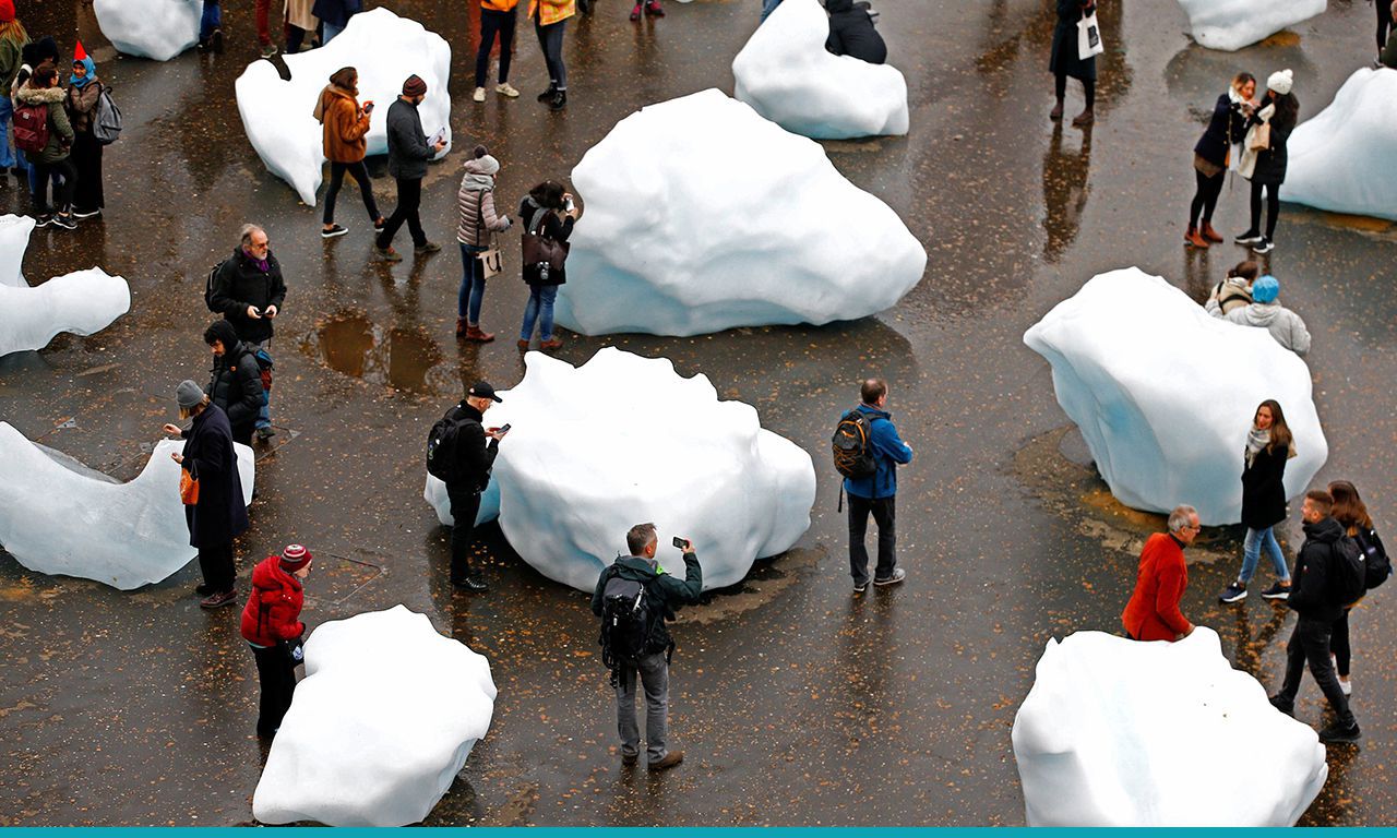 Bezoekers van het Tate Modern in Londen lopen door ‘Ice Watch’, een installatie van grote blokken ijs van kunstenaar Olafur Eliasson.