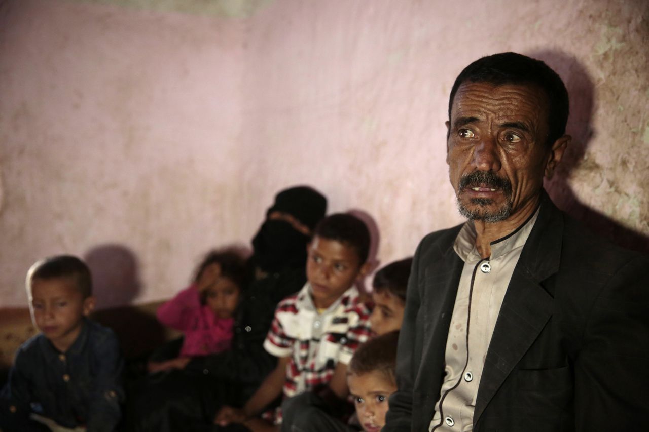 Een man zit eind juli met zijn familie in zijn huis in Sanaa nadat zijn zoon is omgekomen door een bom.
