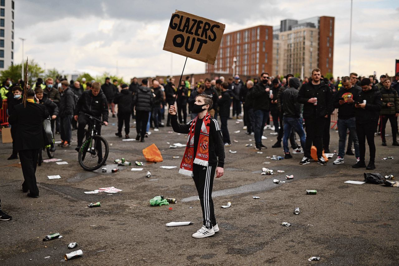 Een jonge fan van Manchester United demonstreerde zaterdag tegen de familie Glazer, de eigenaren van de club.