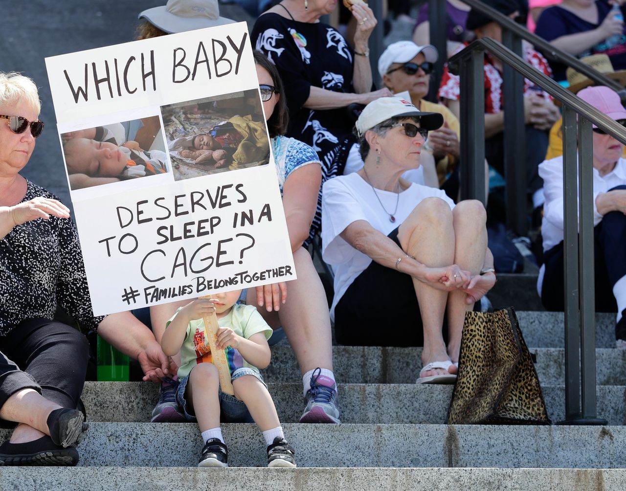 Demonstratie tegen Trumps zero tolerance-immigratiebeleid in Olympia, hoofdstad van de staat Washington. ‘Welke baby verdient het in een kooi te moeten slapen?’, staat op het bord.