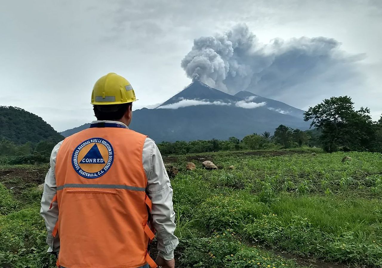 Een medewerker van noodhulporganisatie CONRED kijkt naar de rokende vulkaan.