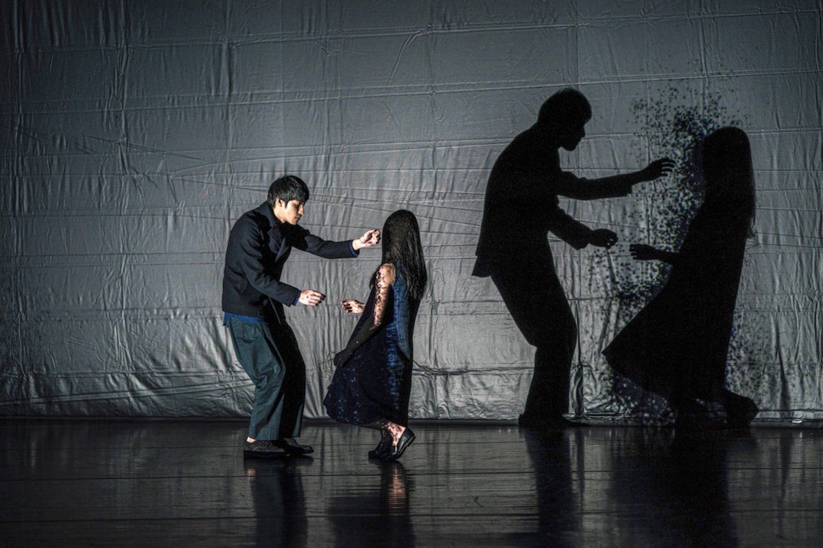 Danser en choreograaf Huang Yi danst in ‘Under the Horizon’ met silhouetten op het filmdoek.