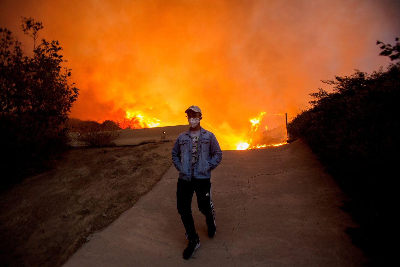Een man loopt weg van de omvangrijke Blue Ridge-bosbrand op 26 oktober 2020 bij de plaats Yorba Linda in Californië.