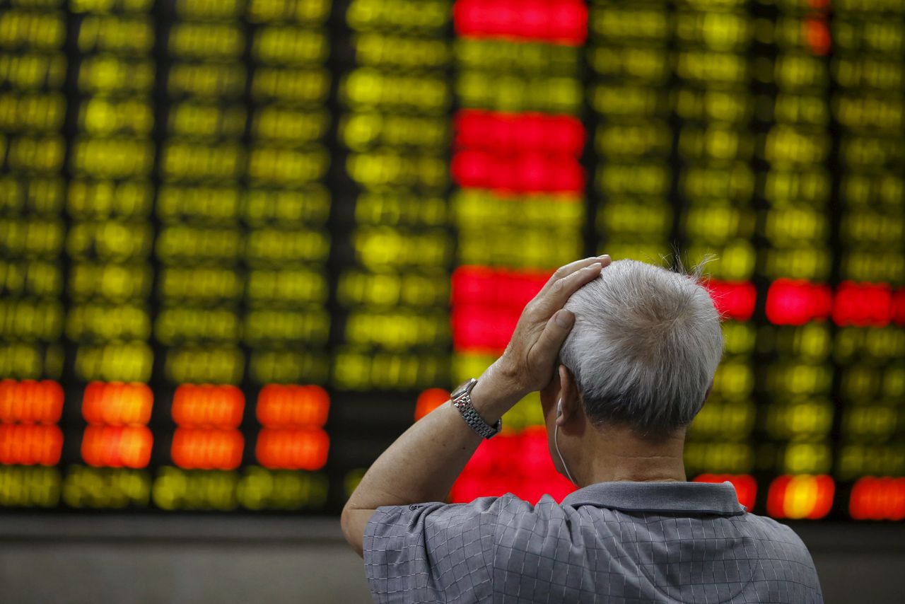 Een investeerder bekijkt de koersinformatie in een handelshuis in Shanghai.