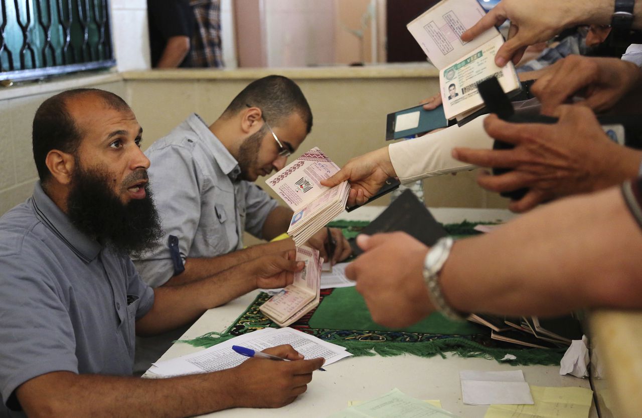 Palestijnen tonen hun papieren bij de grensovergang met Rafah.