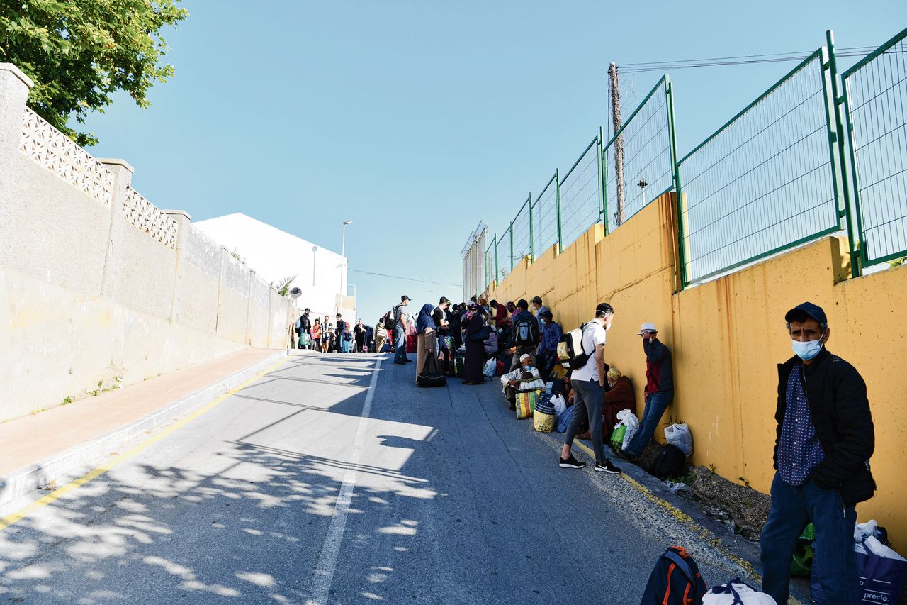 Gestrande Marokkanen wachten in de Spaanse exclave Cueta op een bus die ze zal repatriëren.