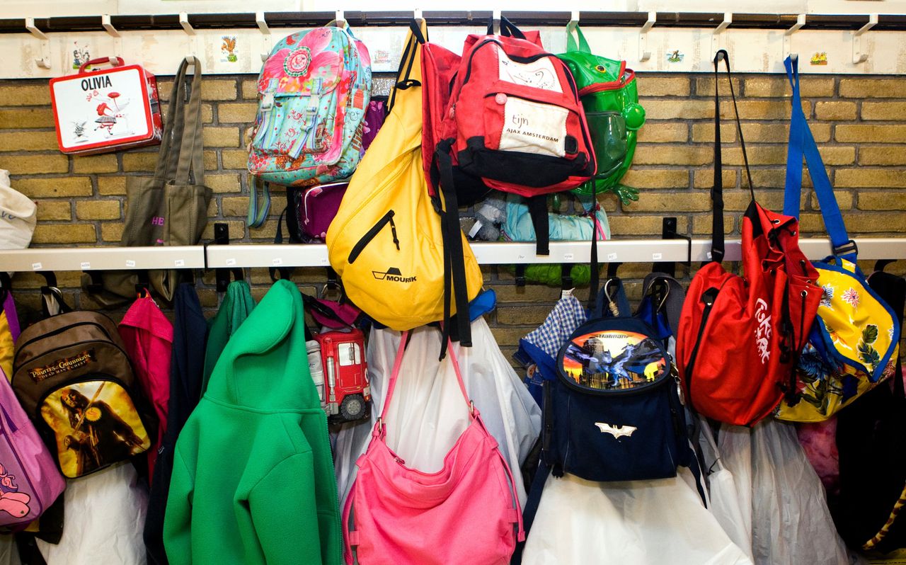 Schooltassen, rugzakken en jassen aan de kapstokken in de gang van een school in Haarlem